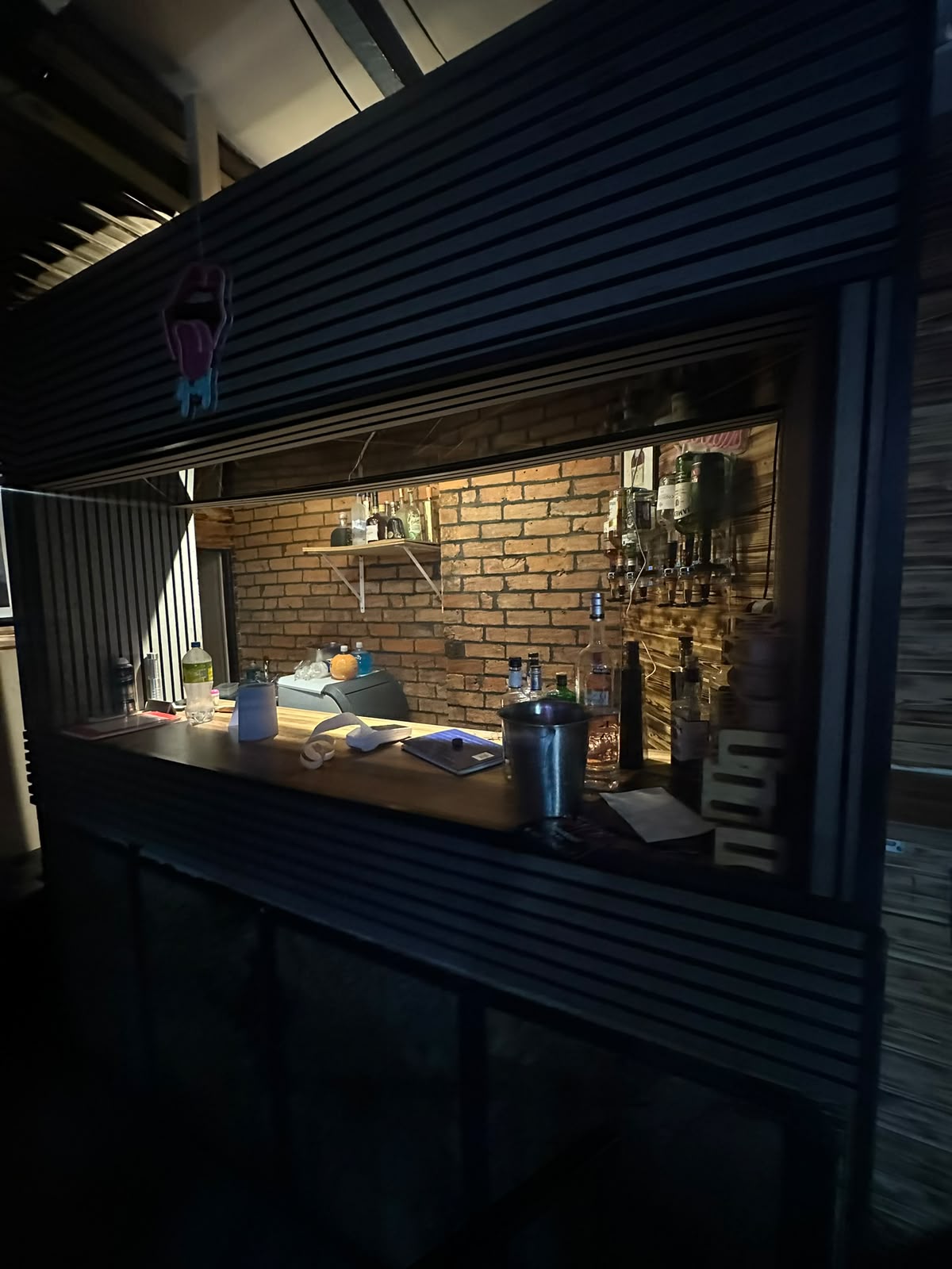 Manna Haus bar counter with spirits on the brick back wall